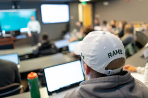 student in class wearing a CSU Rams hat