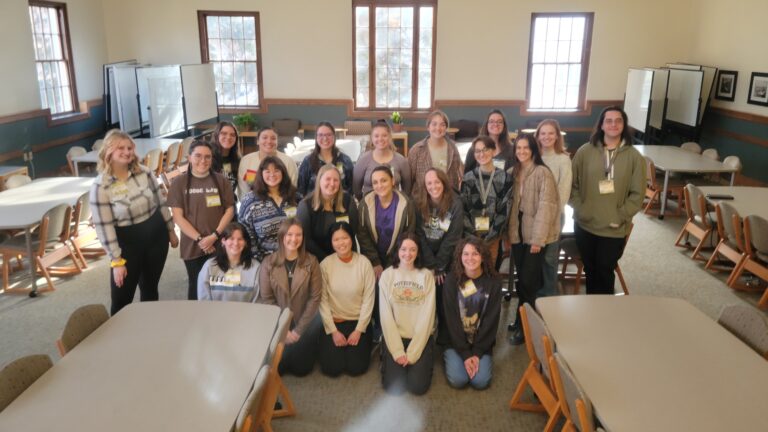 A group of 21 student tutors pose in the TILT great hall