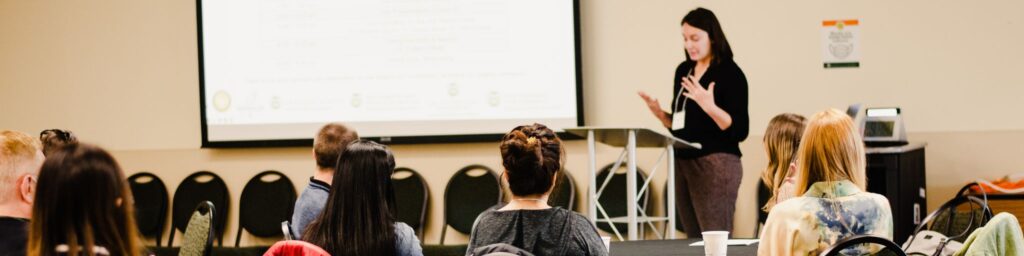Photo of teacher standing at mobile podium lecturing to students in classroom