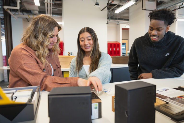 Three graduate students collaborate in the Nancy Richardson Design Center's fabrication labs
