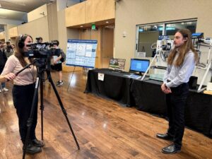 Joshua Kates being interviewed by Denver 9News at E-Days for his senior design project, FlocBot.